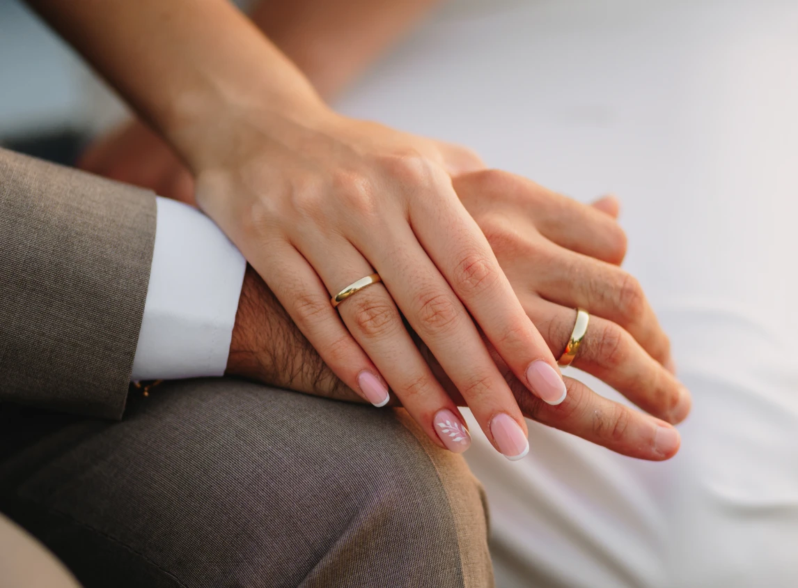 Couple holding hands, wearing rings